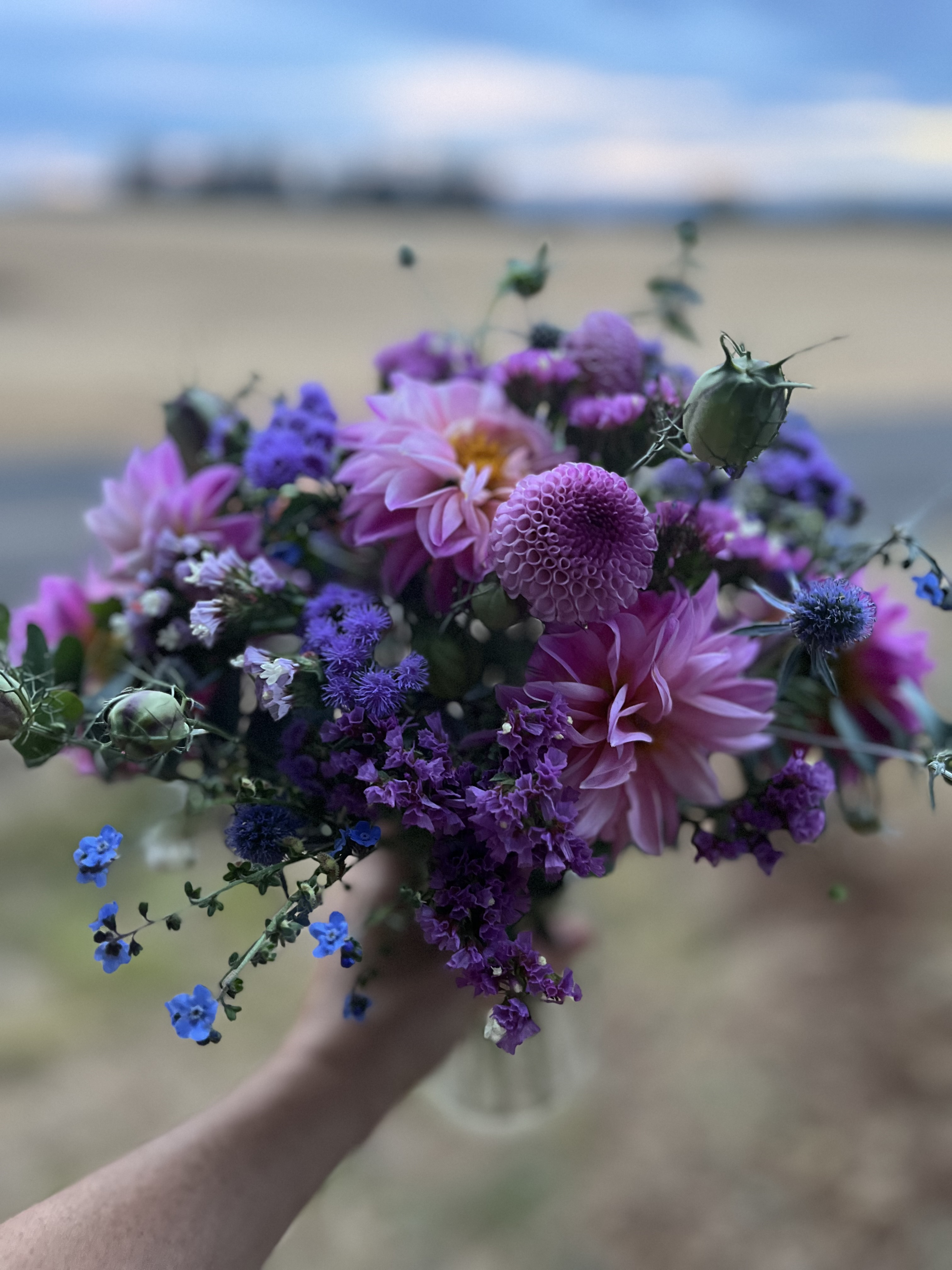 elegant floral arrangement with purple and white roses, professional photography, dark moody lighting